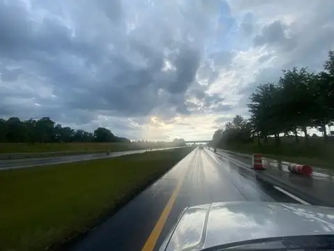 Wet pavement mirrors a dramatic sky.